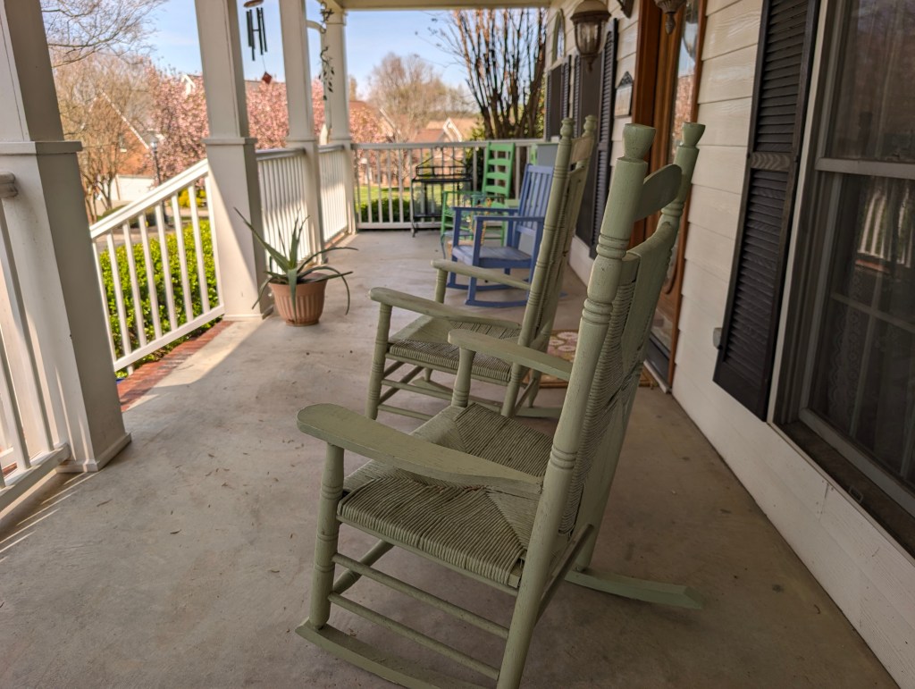 Front porch with empty rocking chairs in soft morning light